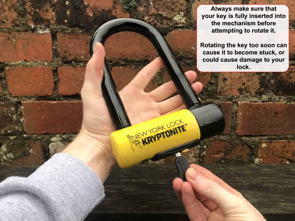 inserting the key of a bike lock into the cylinder to remove any debris from inside