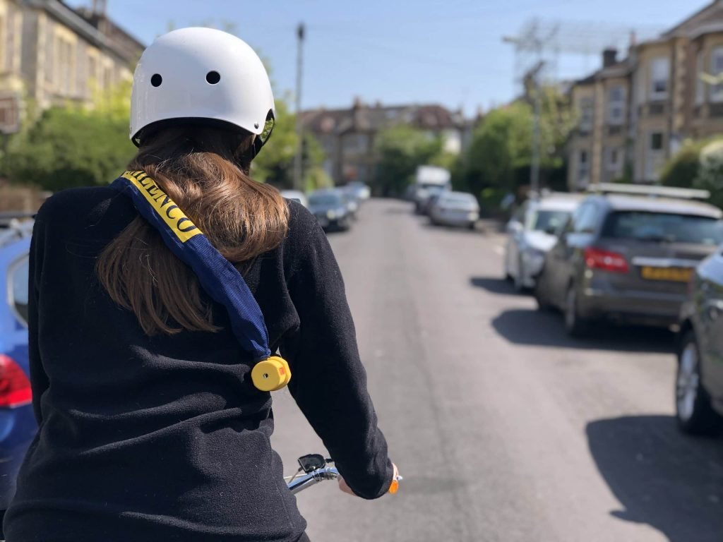 Girl cycling with bike chain over shoulder