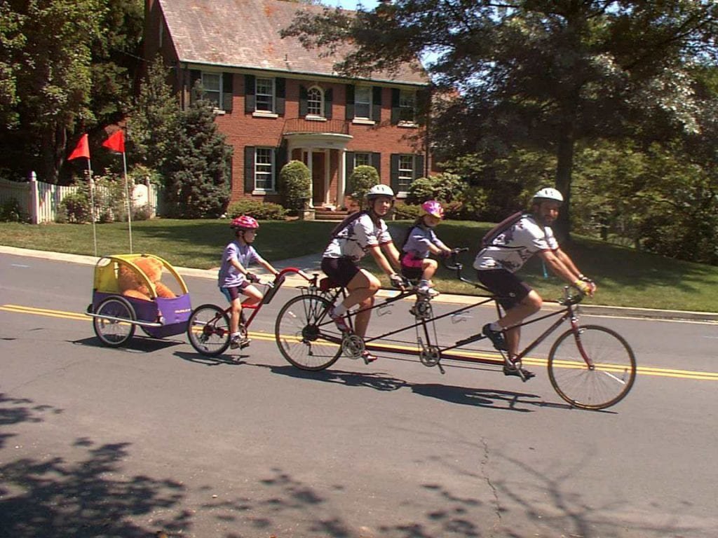 Family riding a tandem bike with children