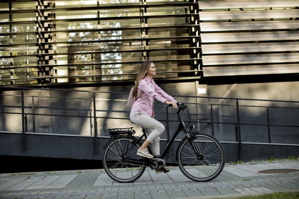 young woman riding electric city bike