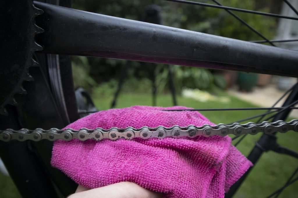 Applying lubricant to bike chain after rust removal